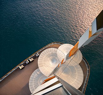 Aerial view of a cruise ship deck with stylish sunshades and loungers over the shimmering sea | MSC Cruises