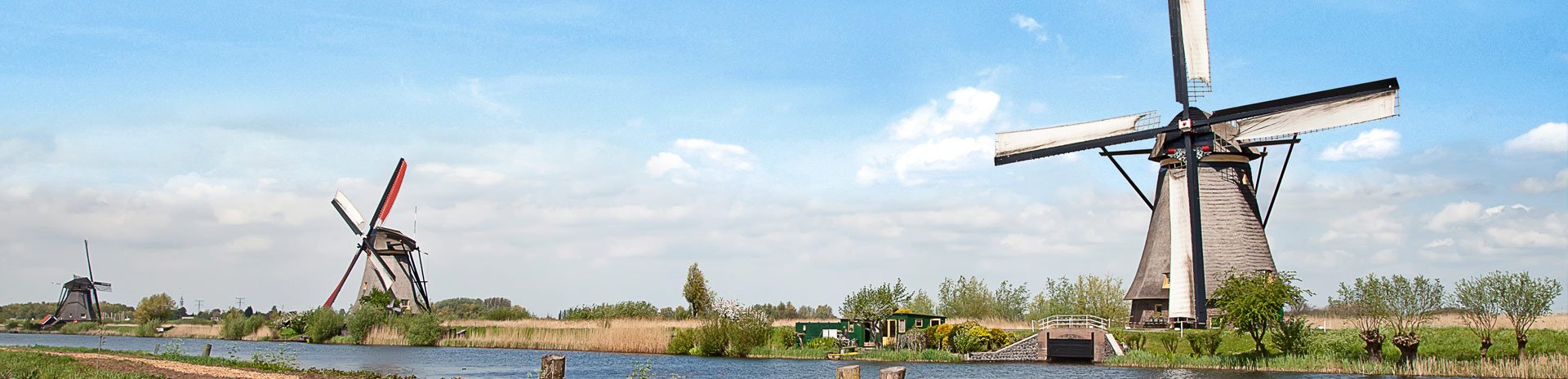 Windmills along a serene canal in the Dutch countryside | MSC Cruises Windmills along a serene canal in the Dutch countryside | MSC Cruises