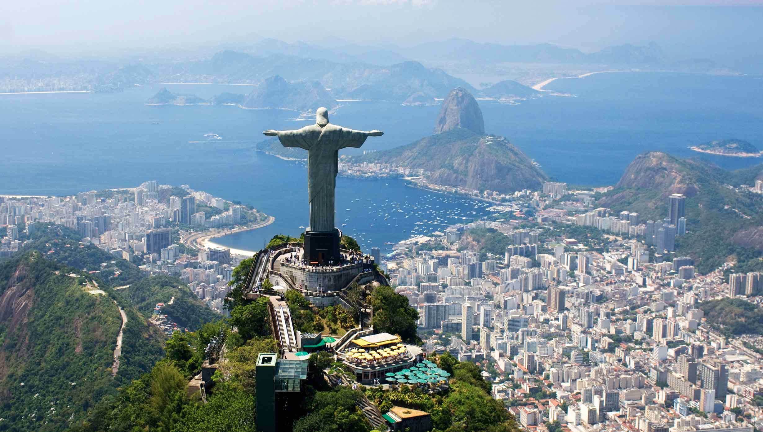 Christ the Redeemer overlooking Rio de Janeiro with Sugarloaf Mountain and the bay in the background | MSC Cruises
