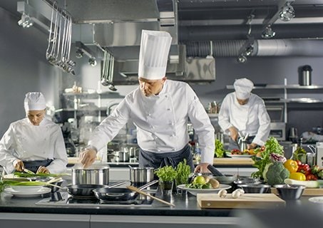Chefs preparing gourmet dishes in a professional kitchen onboard | MSC Cruises Chefs preparing gourmet dishes in a professional kitchen onboard | MSC Cruises
