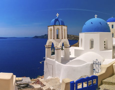 Santorini's iconic blue-domed churches overlooking the Aegean Sea | MSC Cruises