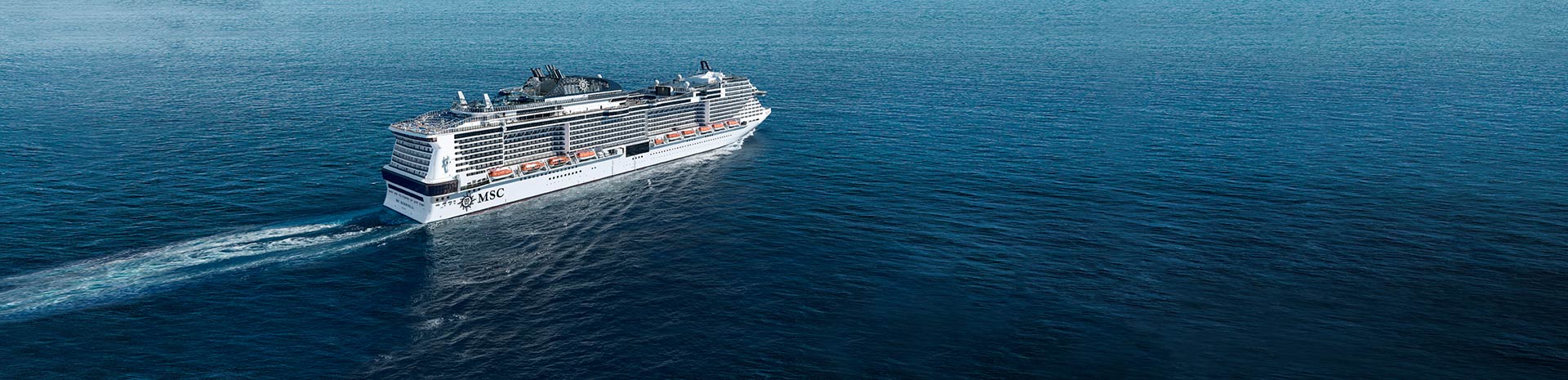 An MSC cruise ship sailing across calm blue waters | MSC Cruises An MSC cruise ship sailing across calm blue waters | MSC Cruises
