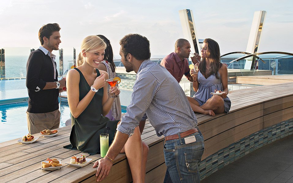 Guests enjoying cocktails and appetizers by the pool on a cruise ship deck | MSC Cruises Guests enjoying cocktails and appetizers by the pool on a cruise ship deck | MSC Cruises