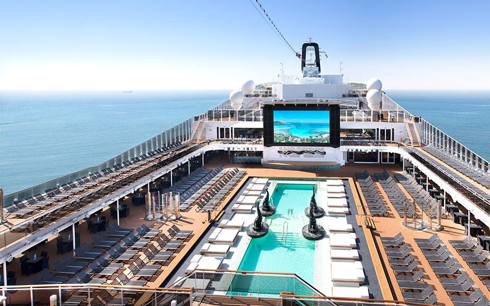 Luxurious cruise ship deck with pool, sun loungers, and ocean views | MSC Cruises