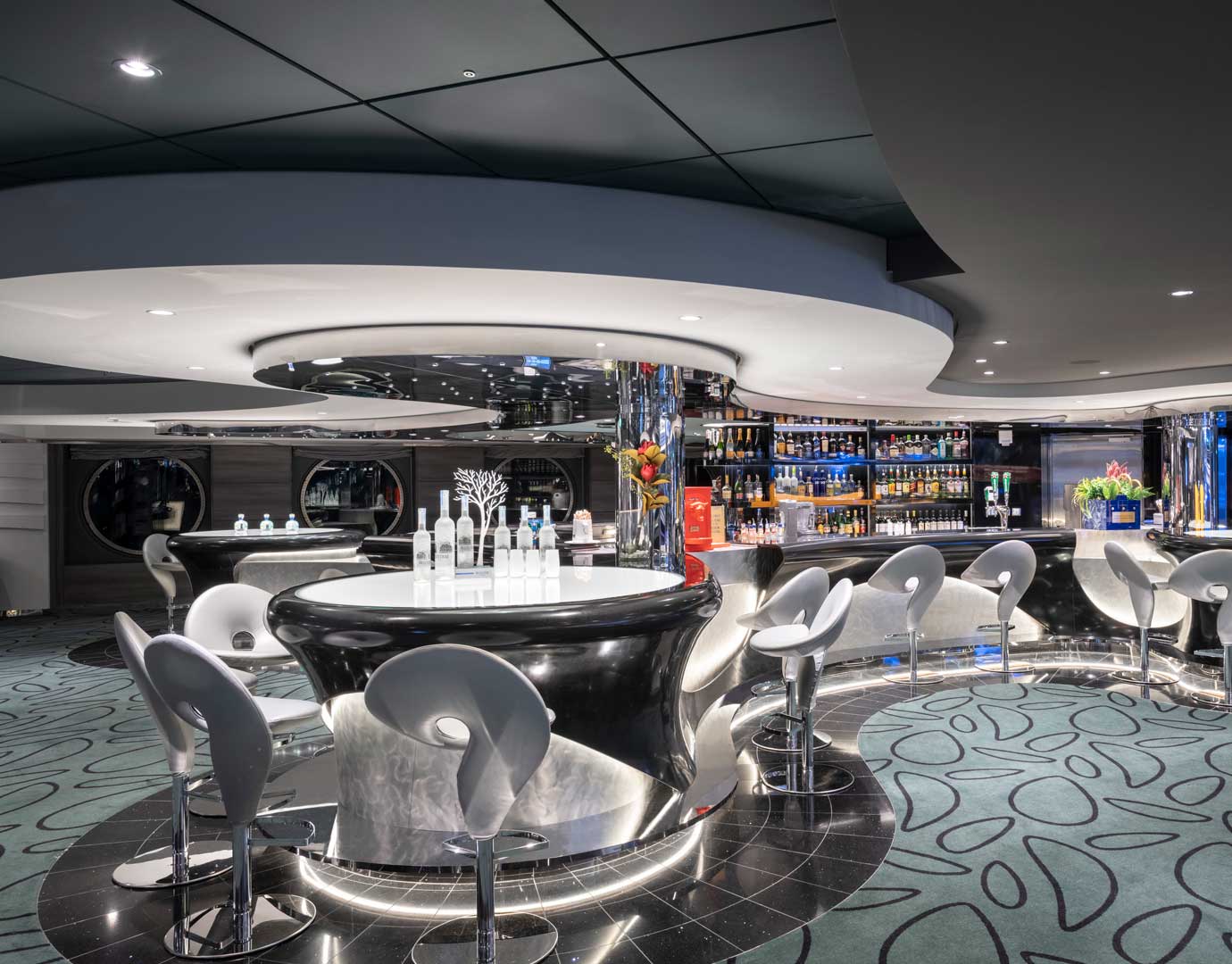 Modern onboard bar with sleek design and illuminated seating area | MSC Cruises Modern onboard bar with sleek design and illuminated seating area | MSC Cruises