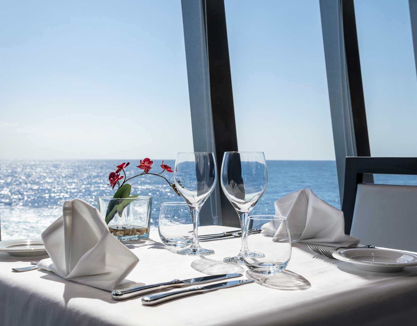 Elegant table setup with ocean view aboard a cruise ship | MSC Cruises Elegant table setup with ocean view aboard a cruise ship | MSC Cruises